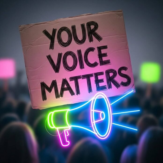 Protest sign: "Your Voice Matters" with neon megaphone and blurry crowd.