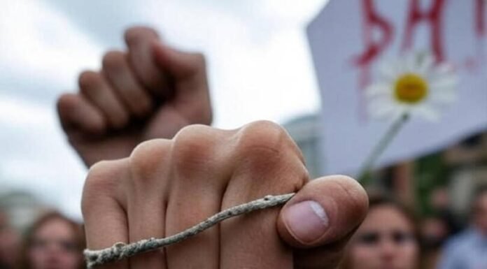 Fighting for Choice: The Women Leading the Movement Gritty protest scene, woman's fist with worn bracelet, dripping sign, daisy in megaphone.