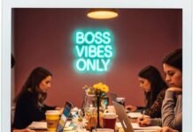 Why Women Are the Future of Entrepreneurship Polaroid of women working in a messy co-working space with a neon sign.