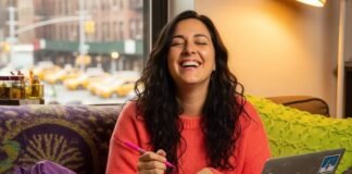 How Brands Are Listening to Women—And Why It Works A woman laughing, sketching product boxes on a napkin in a cozy, cluttered apartment.