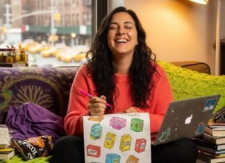 How Brands Are Listening to Women—And Why It Works A woman laughing, sketching product boxes on a napkin in a cozy, cluttered apartment.